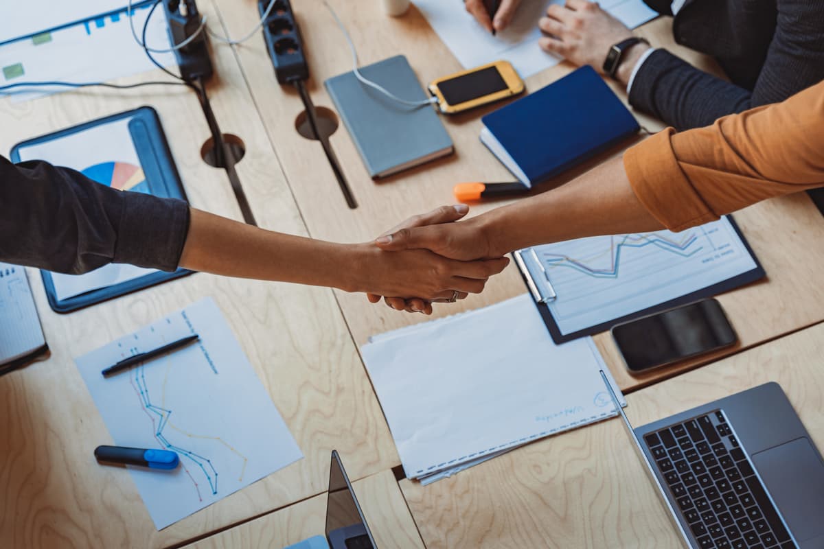 Professioneller Handschlag zwischen Geschäftspartnern - Vertrauensvolle Zusammenarbeit und persönliche Beratung bei Unternehmensgründung und IT-Consulting